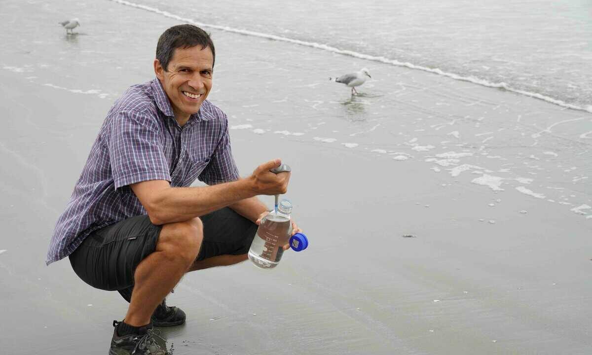 Scientist takes water sea sample at beach