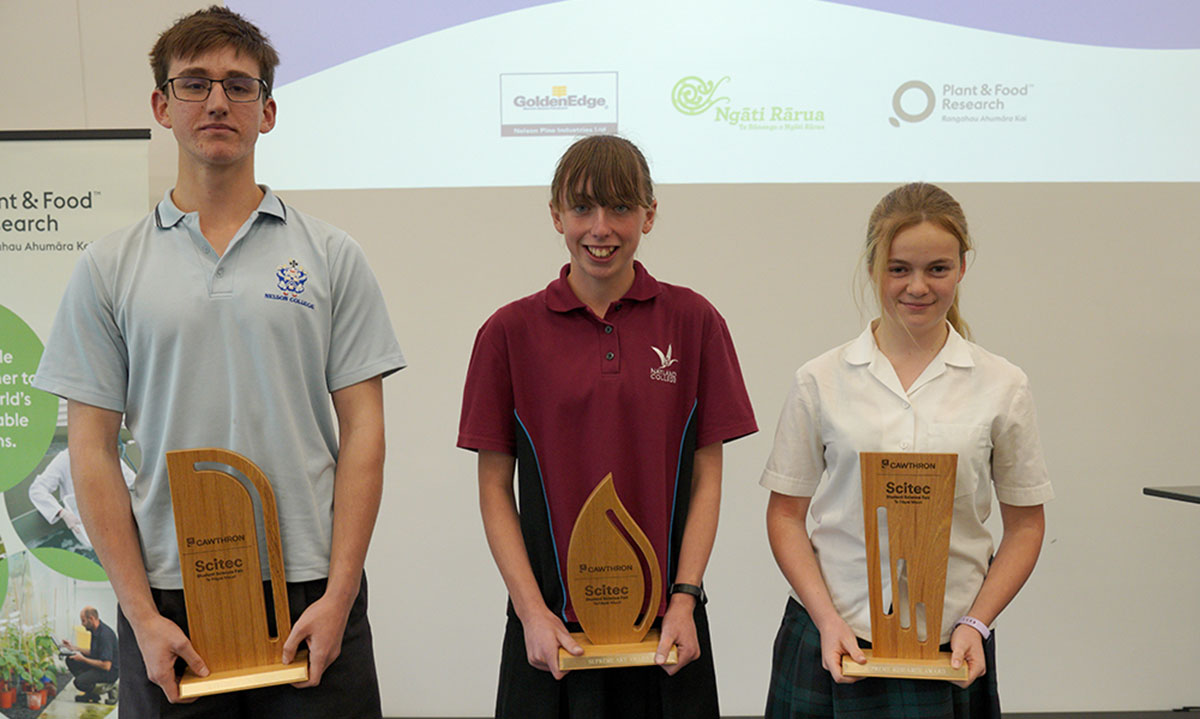 Three students holding trophies